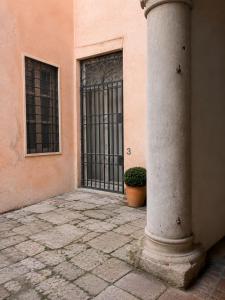 a building with a gate and a pillar with a plant at Le Dimore della Seta - Palazzo Busdraghi in Lucca