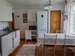 a kitchen with a table and chairs and a kitchen with white cabinets at Hirsipirtti in Inari