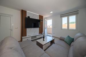 a living room with a couch and a tv at Andrej Apartmani Rafailovici in Rafailovici