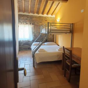 a bedroom with two bunk beds and a table at Rustic Refuge in the Hills in Santa Luce