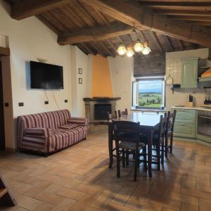 a kitchen and living room with a table and chairs at Rustic Refuge in the Hills in Santa Luce