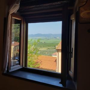 a window with a view of a roof at Rustic Refuge in the Hills in Santa Luce