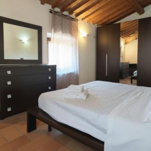 a bedroom with a bed with a dresser and a mirror at Rustic Refuge in the Hills in Santa Luce +2 photos