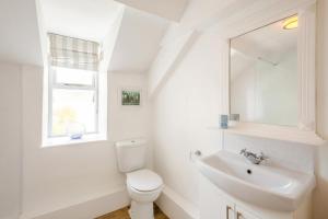 a white bathroom with a toilet and a sink at 2 Bed in Pwllheli oc-44492 in Nefyn +26 photos