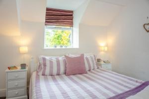 a bedroom with a bed with pink and white stripes at 2 Bed in Pwllheli oc-44492 in Nefyn