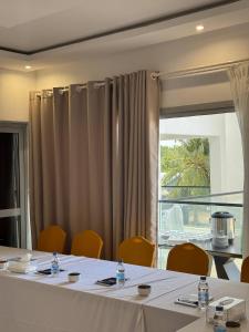 a dining room with a table and chairs and a window at Family House Assinie in Assinie +36 photos