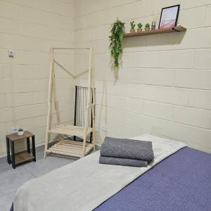 a room with a bed and a chair and a wall at Kitnet Completa em Cotia com Garagem 04 in Cotia