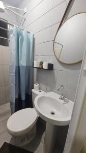 a bathroom with a toilet and a sink and a mirror at Kitnet Completa em Cotia com Garagem 04 in Cotia