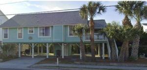 a blue house with palm trees in front of it at The Gentleman Pirate in Edisto Island