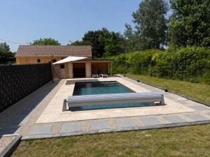 a swimming pool in a yard with a house at Chalet en bois indépendant, terrasse et accès piscine in Montret