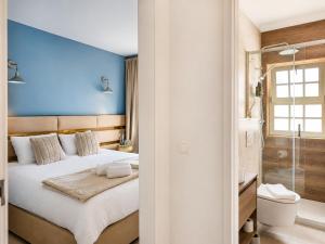 ein Schlafzimmer mit einer blauen Wand, einem Bett und einem Badezimmer in der Unterkunft Opus House in Guimarães + 58 Fotos