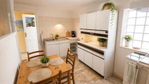 a kitchen with a wooden table and a kitchen with white cabinets at unterkunft Cuxhaven in Cuxhaven