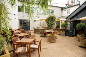 an outdoor patio with tables and chairs and plants at The Globe, Warwick, Warwickshire - Brunning & Price in Warwick