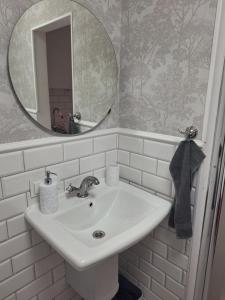 a white sink in a bathroom with a mirror at Domek Za Wyspą 3 in Chmielów