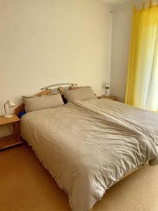 a large bed in a bedroom with a yellow curtain at Apartment with Terrace & Garden View in Zwiesel