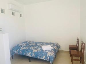 a small room with a bed and a chair at Studio Cangrejos in Los Médanos Partidos