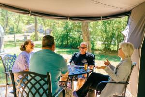 a group of people sitting at a table under a tent at Peaceful Dome Getaway in the Catskills in Gilboa