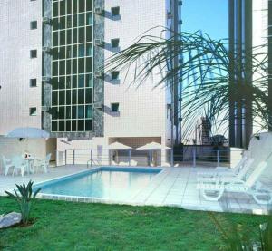 a swimming pool in front of a building at Flat Niagara Belo Horizonte in Belo Horizonte