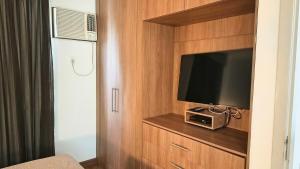 a room with a tv in a cabinet with a television at Flat Niagara Belo Horizonte in Belo Horizonte