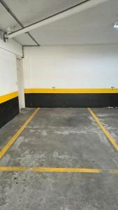an empty parking garage with yellow and white walls at Flat Niagara Belo Horizonte in Belo Horizonte