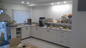 a kitchen with white cabinets and food on shelves at Sea Garden, Residência in Peniche