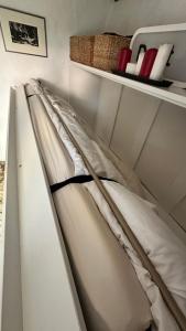 a white bed in a room with a shelf at Garden View Homestay in Historic Patcham, Brighton in Brighton & Hove