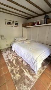 a large white bed in a room with a rug at Garden View Homestay in Historic Patcham, Brighton in Brighton & Hove