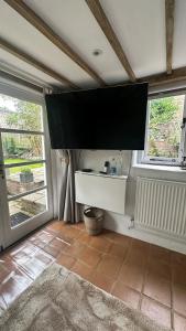 a living room with a large tv on the wall at Garden View Homestay in Historic Patcham, Brighton in Brighton & Hove