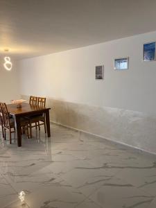 a dining room with a table and chairs against a wall at W3 property in Kerak