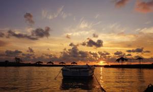 a boat in the water with a sunset in the background at Captain's House in Filiatra