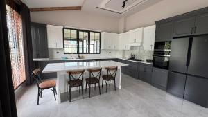 a kitchen with a large island with bar stools at Villa suit in Trabzon