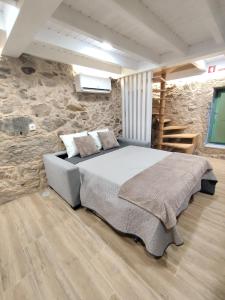 a bedroom with a bed and a stone wall at Abrigo da Serra - Soajo Mountain Lodge in Adrão