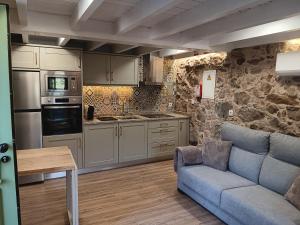 a living room with a couch and a kitchen at Abrigo da Serra - Soajo Mountain Lodge in Adrão