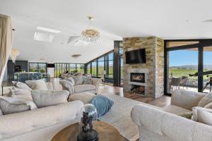 a living room with couches and a fireplace at The Retreat at Strashleigh Manor Farm - A Luxury Devon Country Escape in Ivybridge