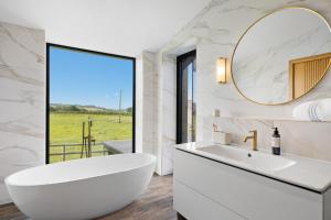 a bathroom with a white tub and a large mirror at The Retreat at Strashleigh Manor Farm - A Luxury Devon Country Escape in Ivybridge +72 photos