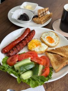 a plate of breakfast food with sausage eggs and toast at Karibi in Kyzylorda