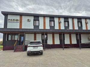a white car parked in front of a building at Karibi in Kyzylorda