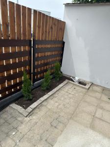 a fence with plants in front of a patio at Imperial Apartament in Gniezno