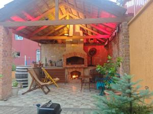 a patio with a fireplace and a table and chairs at Guesthouse Mery in Kobuleti