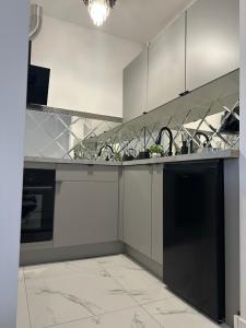 a kitchen with a black and white counter top at Imperial Apartament in Gniezno +10 photos