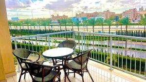 a table and chairs on a balcony with a view of a city at Marassi in El Alamein
