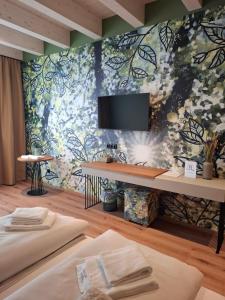 a room with two beds and a tv on a wall at Wald & Wiese Hornstein in Hornstein