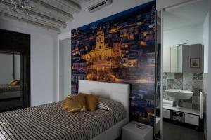 een slaapkamer met een groot schilderij aan de muur bij Casa Matteotti in Modica