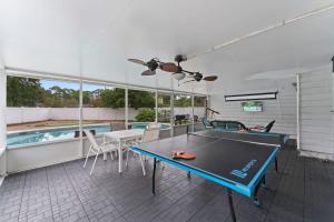 a living room with a ping pong table and a swimming pool at Putt Putt Pool Home - Mini Golf Grill Ping Pong in Jacksonville