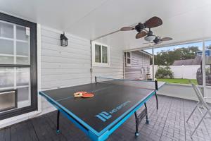 a ping pong table with two chairs and a ceiling fan at Putt Putt Pool Home - Mini Golf Grill Ping Pong in Jacksonville