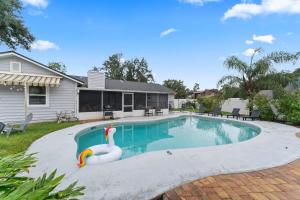 a swimming pool with a toy swan in a yard at Putt Putt Pool Home - Mini Golf Grill Ping Pong in Jacksonville