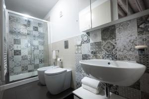uma casa de banho branca com um lavatório e um WC em Casa Matteotti em Modica