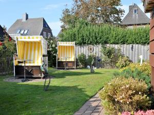 a backyard with two chairs and a fence at Haus Seeflieger in Westerland