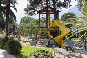 a playground with a slide in a park at Camping Al Porto - Mini Glamping & Mobile Homes in Nago-Torbole