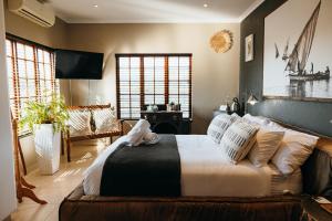 a bedroom with a large bed with white sheets and pillows at Cwebile Guesthouse in Winterton